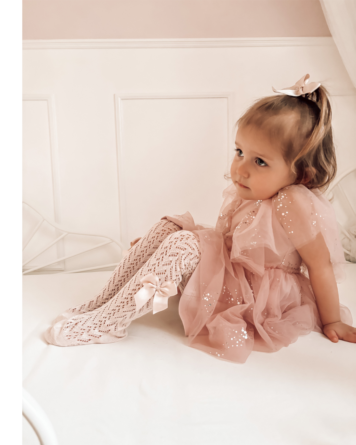 LilleLuxus Condor white pearl knit tights with side grosgrain bow worn by a young girl in a pink tulle dress
